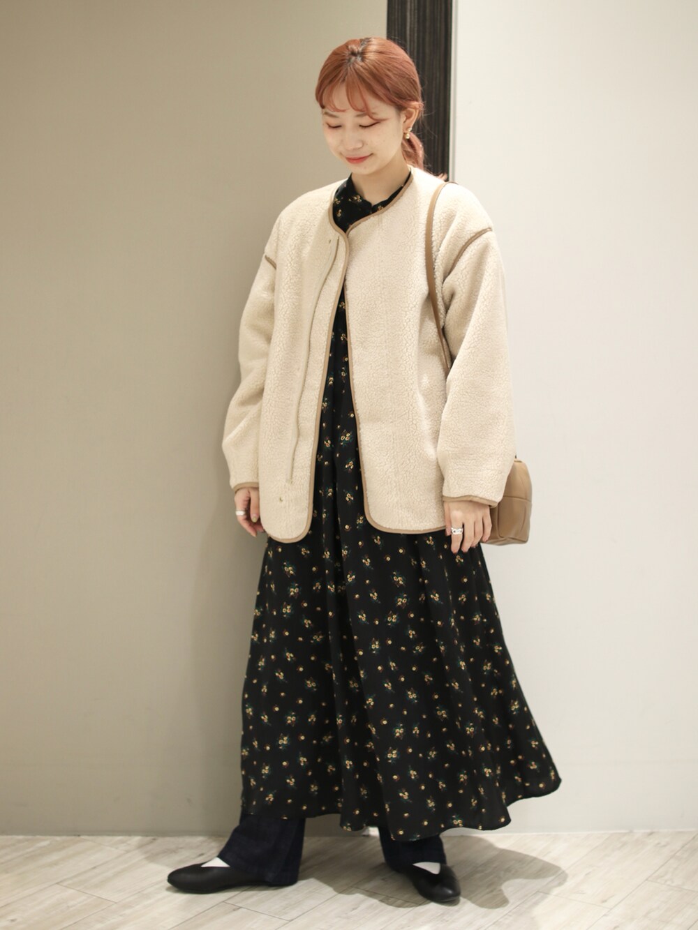 ホワイト系のブルゾン、ブラック系のワンピース、イエロー系のショルダーバッグを着用したレディースの秋コーディネートの2枚目の写真