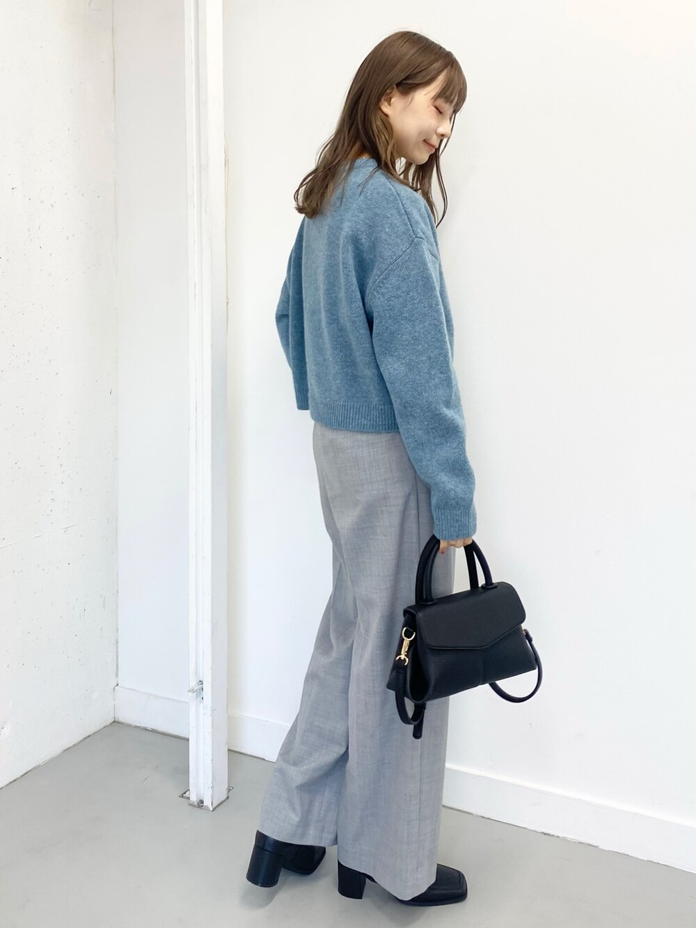 ブラック系のブーツ、グレー系のその他パンツ、ブラック系のショルダーバッグを着用したレディースの冬コーディネートの4枚目の写真