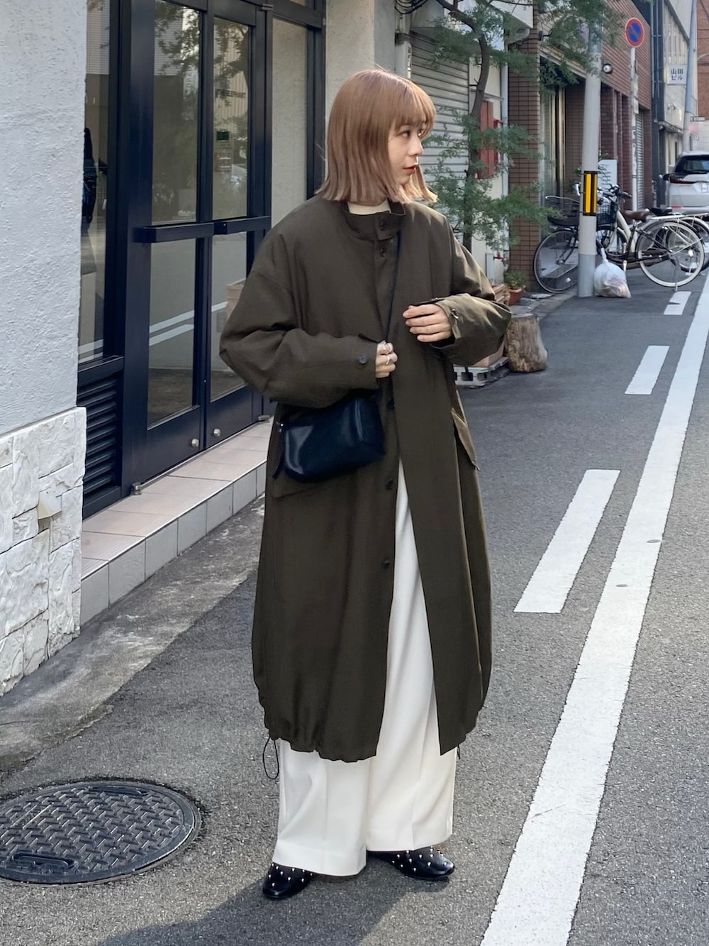 グリーン系のその他アウター、ホワイト系のその他パンツ、ブラック系のパンプスを着用したレディースの冬コーディネートの2枚目の写真