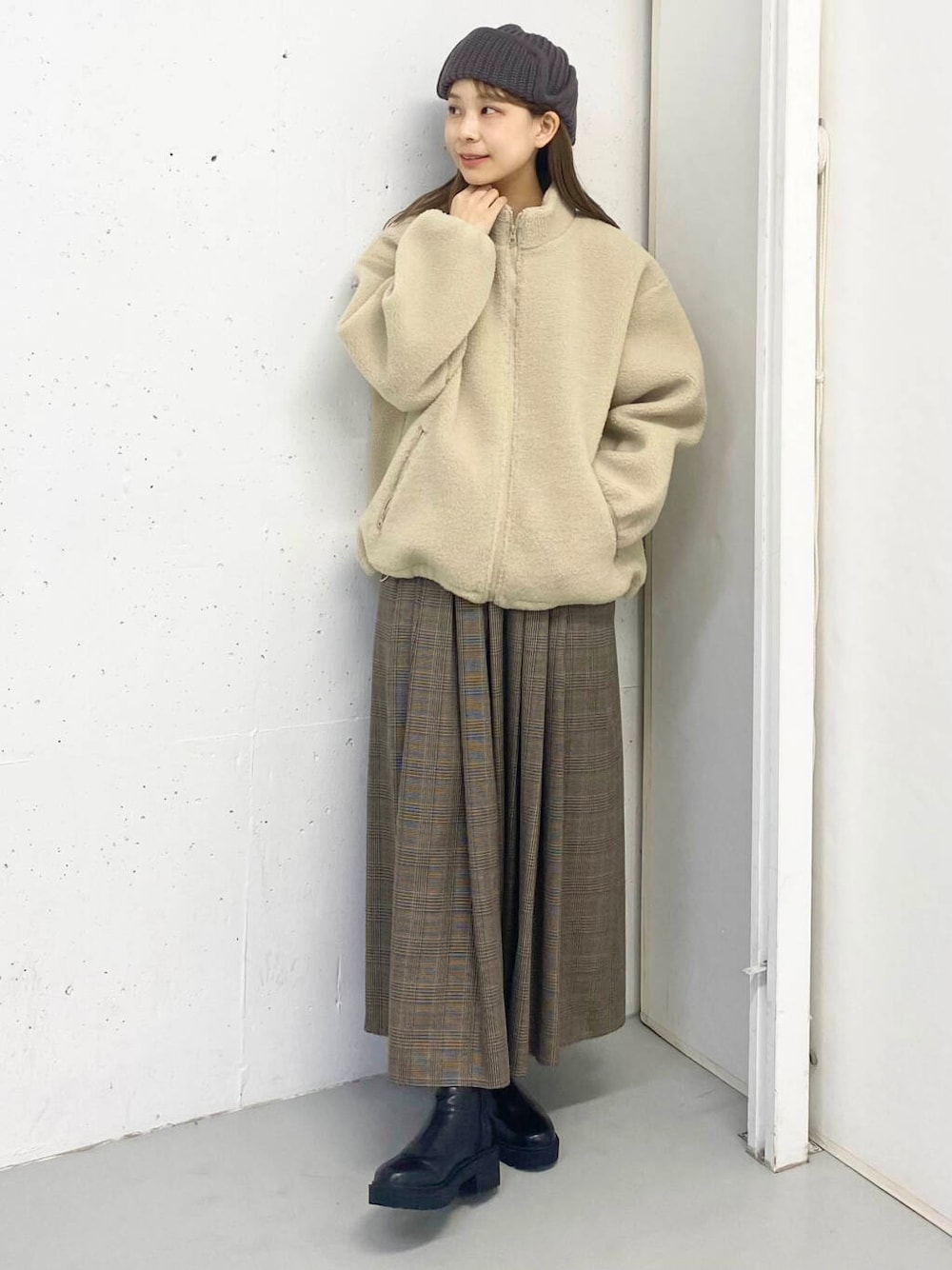 ブラック系のブーツ、その他のスカート、ホワイト系のブルゾンを着用したレディースの秋コーディネートの2枚目の写真