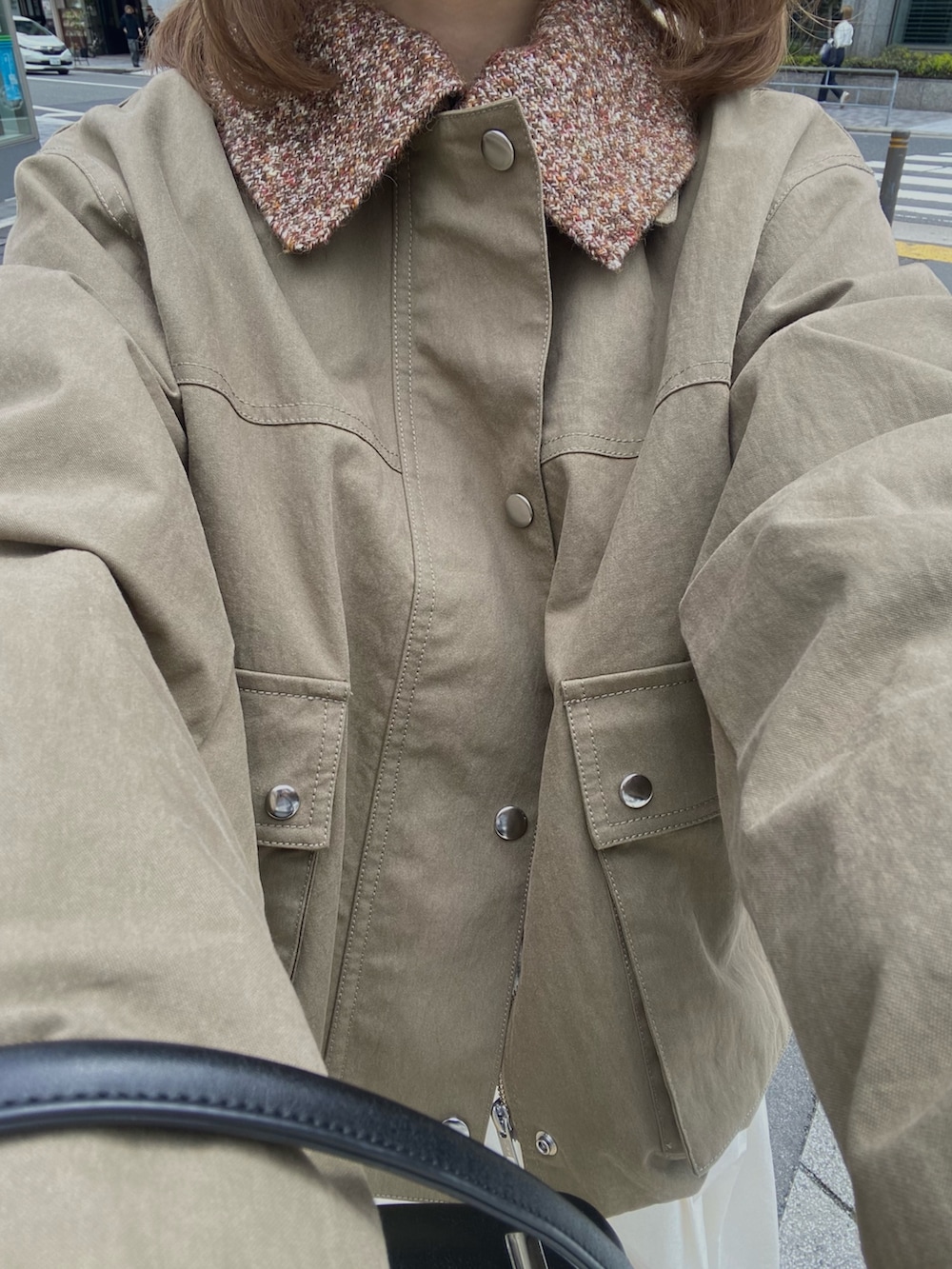 グリーン系のブルゾン、ホワイト系のスカート、ブラウン系のメガネを着用したレディースの春コーディネートの6枚目の写真