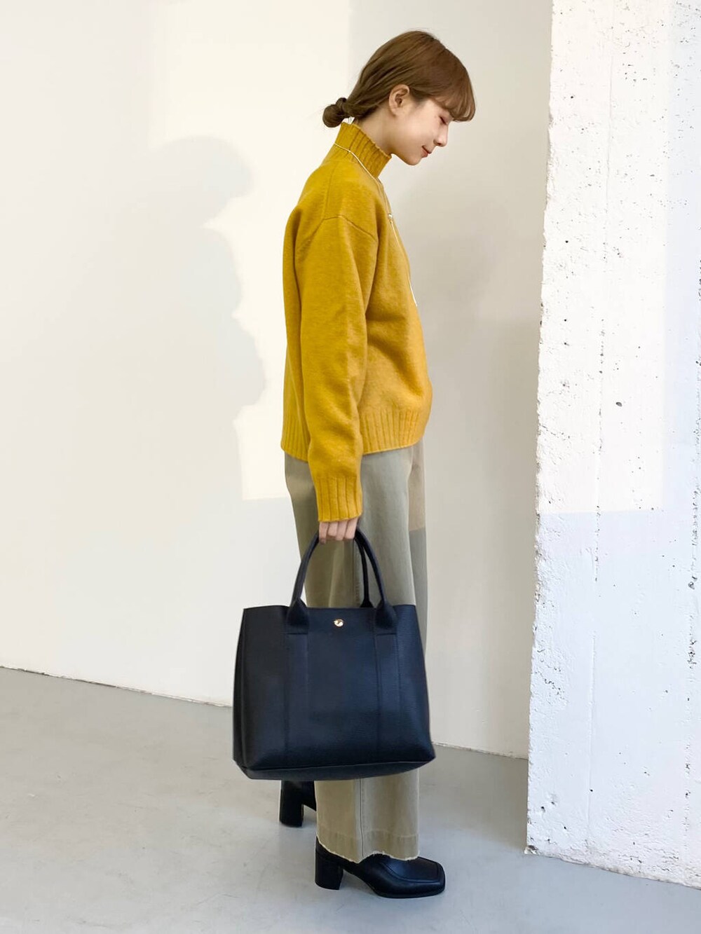 ブラック系のブーツ、ベージュ系のその他パンツ、ブラック系のトートバッグを着用したレディースの冬コーディネートの3枚目の写真