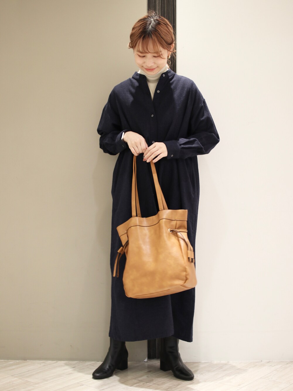 ブルー系のワンピース、ベージュ系のTシャツ/カットソー、ブラック系のブーツを着用したレディースの冬コーディネートの3枚目の写真