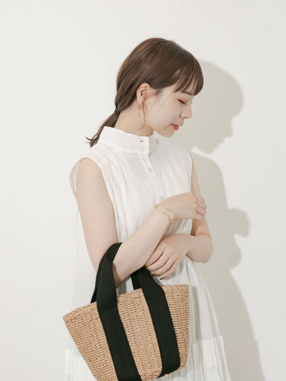 ベージュ系のハンドバッグ、ブラック系のその他パンツ、ホワイト系のワンピースを着用したレディースの夏コーディネートの4枚目の写真