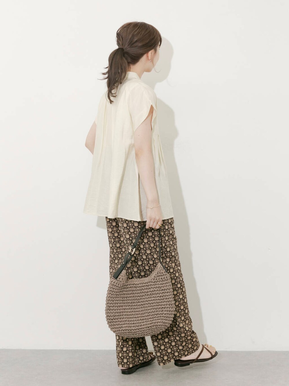 グレー系のトートバッグ、ホワイト系のシャツ/ブラウス、ブラック系のその他パンツを着用したレディースの夏コーディネートの2枚目の写真