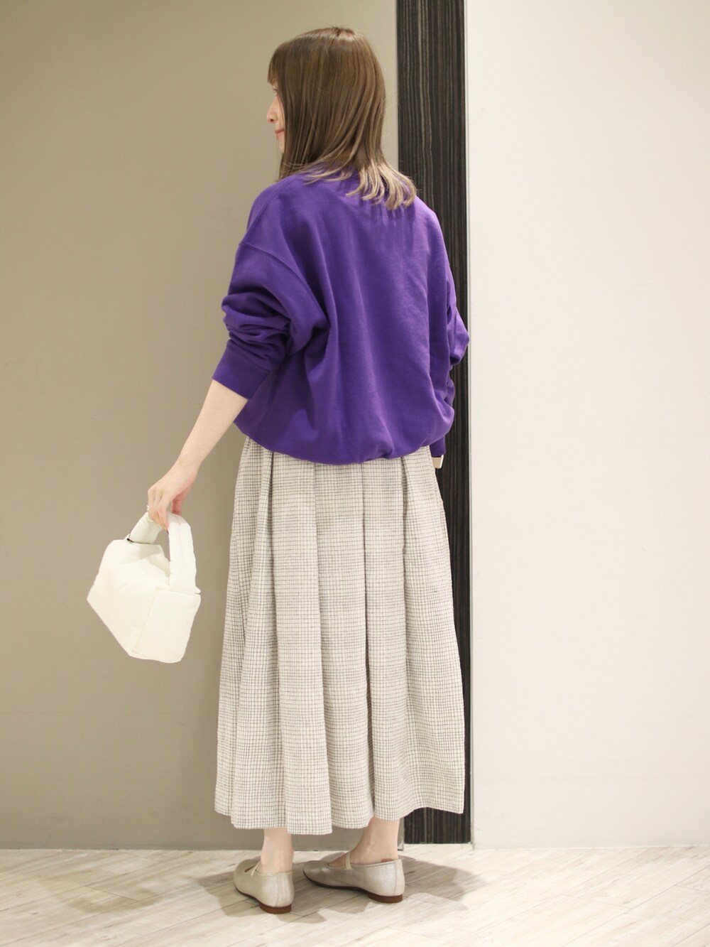 ホワイト系のスカート、パープル系のスウェット、ゴールド系のその他シューズを着用したレディースの秋コーディネートの4枚目の写真