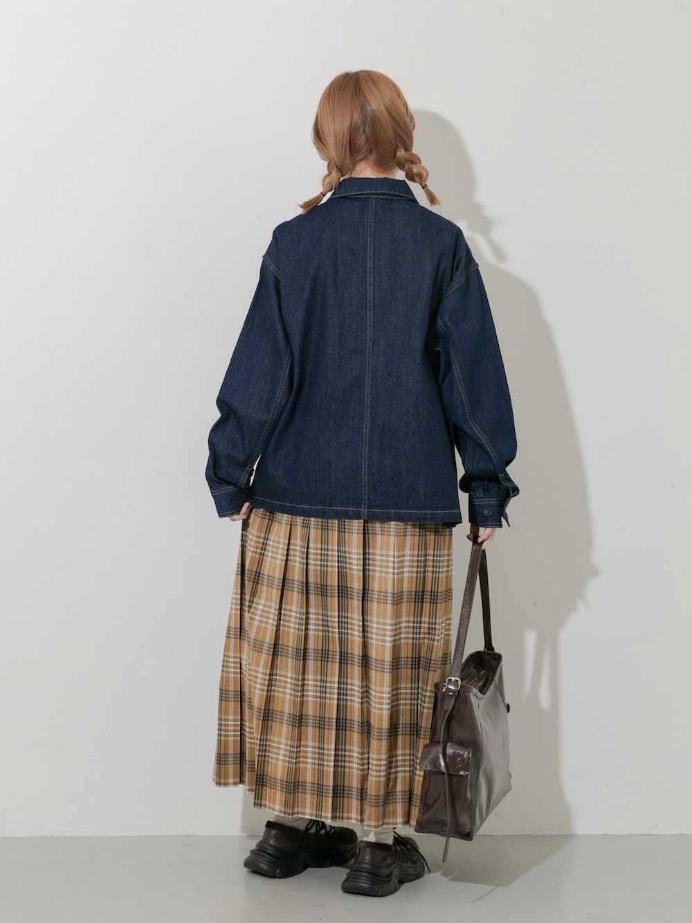 ブラウン系のスニーカー、ブルー系のカバーオール、イエロー系のスカートを着用したレディースの秋コーディネートの3枚目の写真