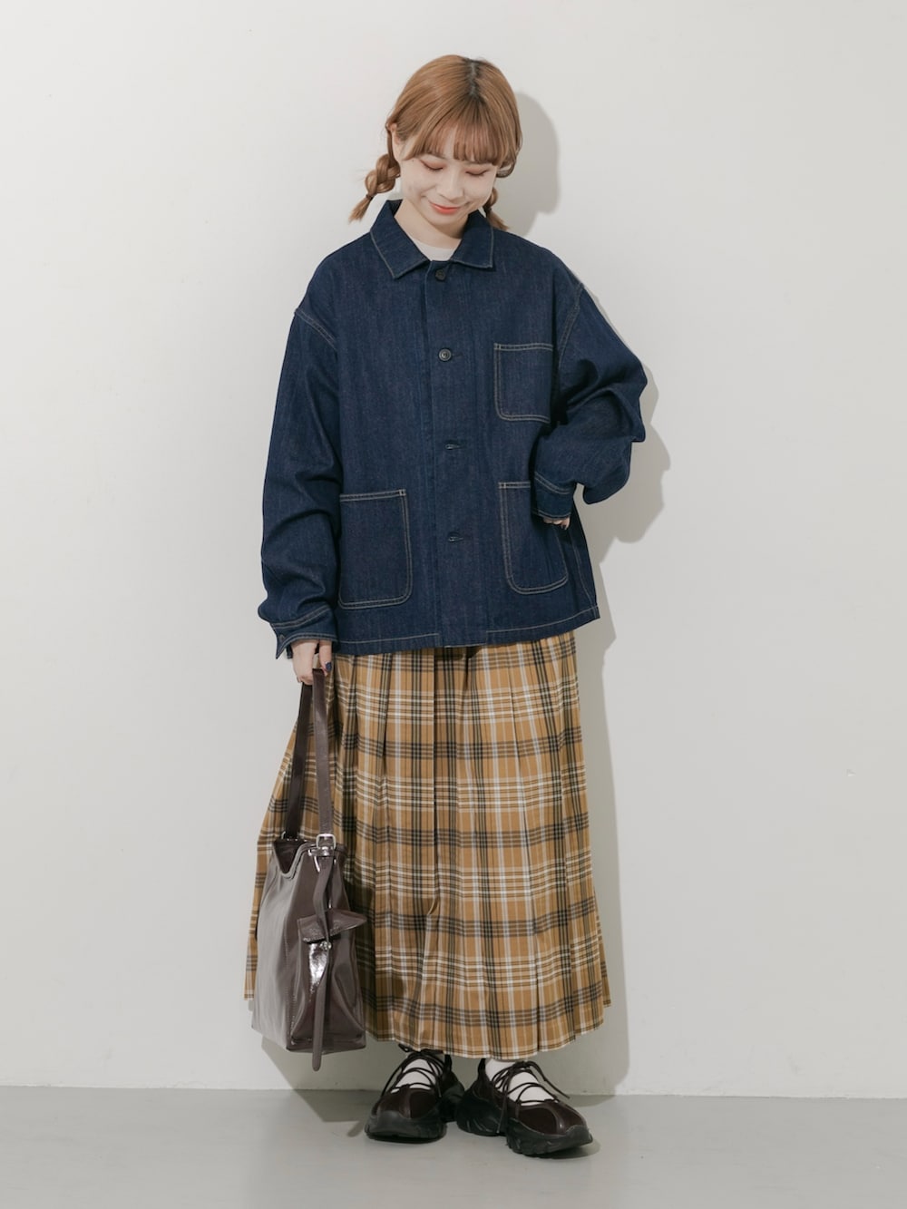 ブラウン系のスニーカー、ブルー系のカバーオール、イエロー系のスカートを着用したレディースの秋コーディネートの2枚目の写真