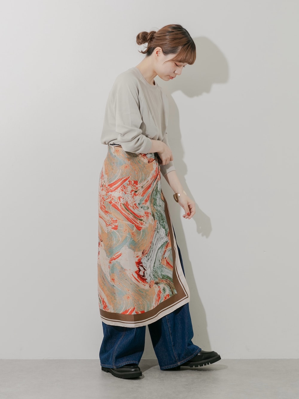 ブラック系のローファー、ベージュ系のTシャツ/カットソー、ブルー系のデニムパンツを着用したレディースの秋コーディネートの3枚目の写真