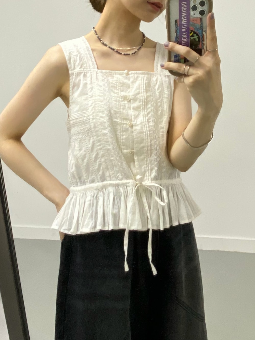 ホワイト系のシャツ/ブラウス、ブラック系のデニムパンツ、ブラック系のサンダルを着用したレディースの夏コーディネートの4枚目の写真