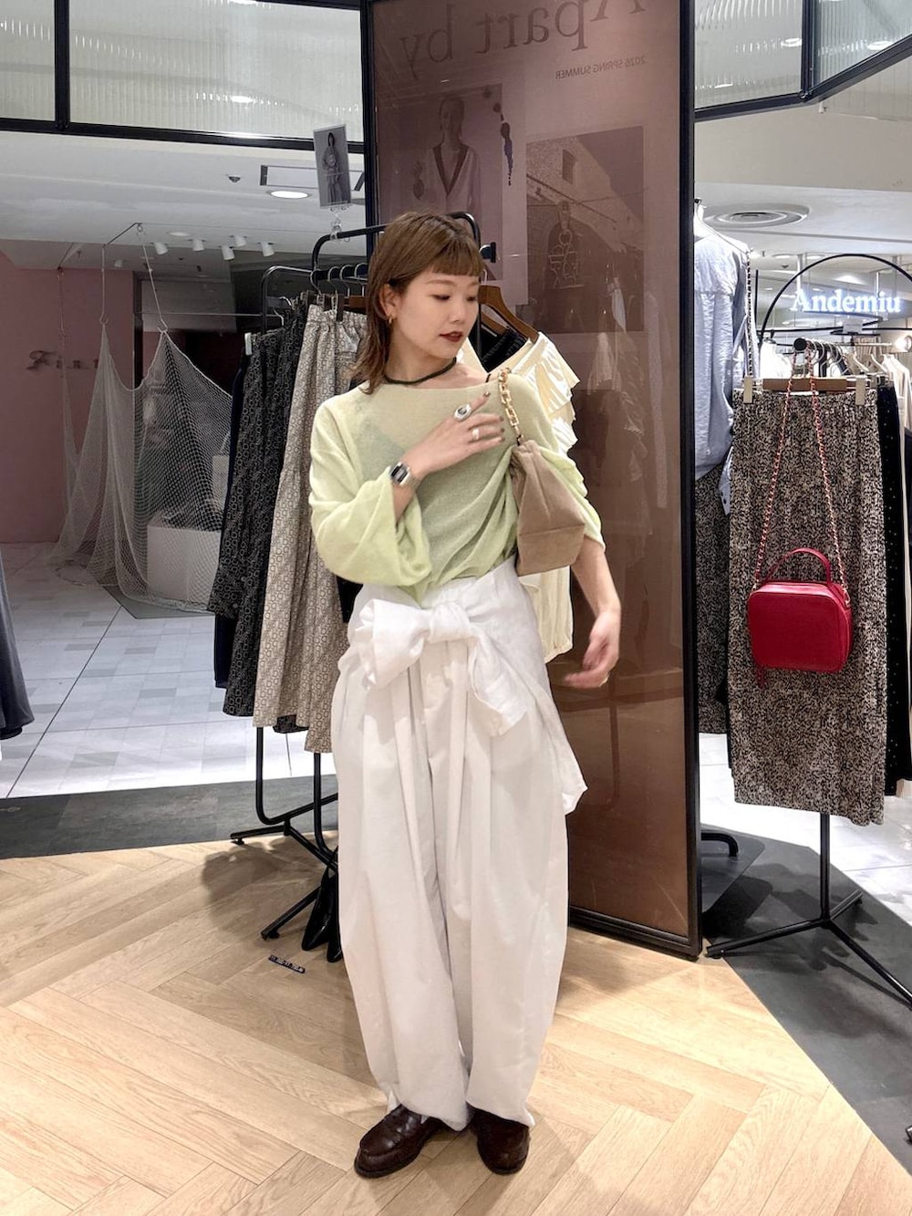 ホワイト系のシャツ/ブラウス、ベージュ系のショルダーバッグ、グリーン系のニット/セーターを着用したレディースの春コーディネートの2枚目の写真