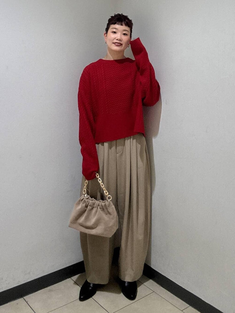 ベージュ系のスラックス、ブラック系のブーツ、ベージュ系のショルダーバッグを着用したレディースの冬コーディネートの2枚目の写真