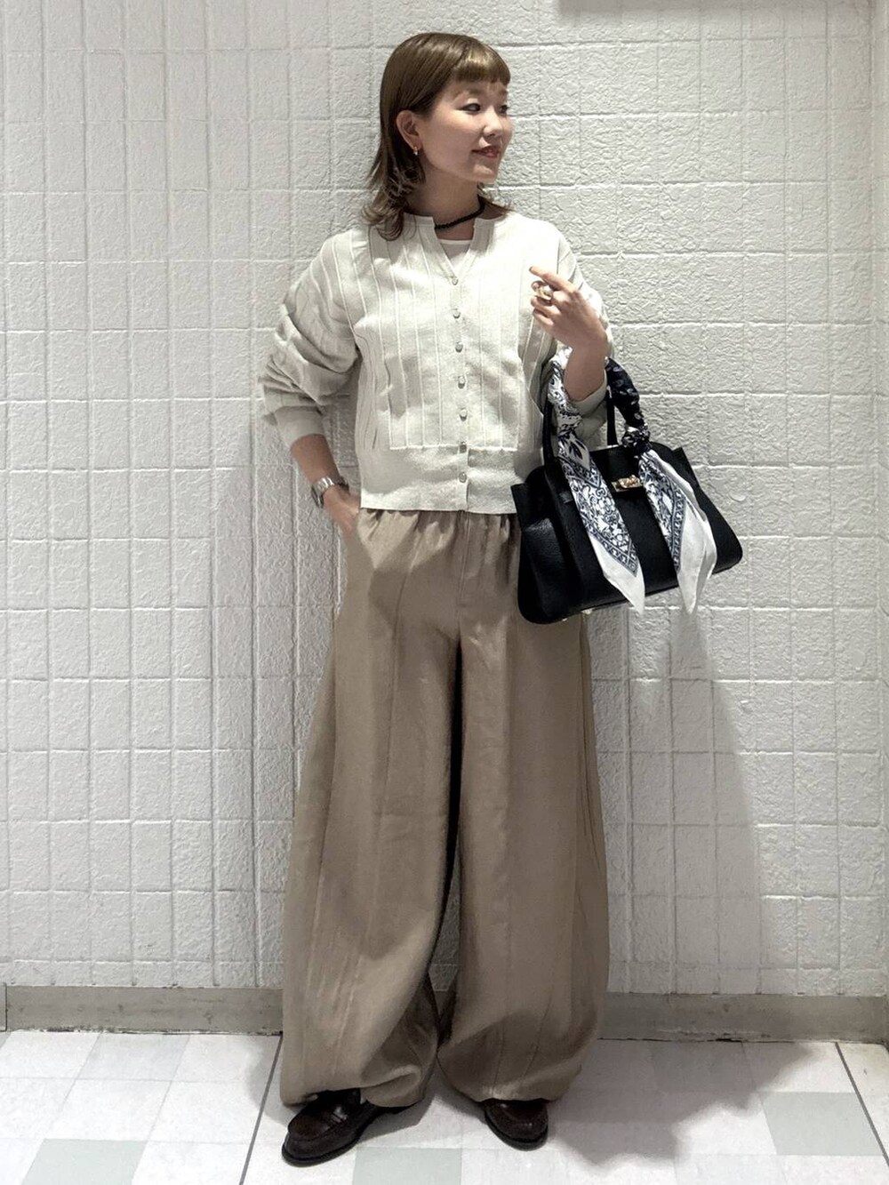 ホワイト系のカーディガン/ボレロ、ベージュ系のその他パンツ、ブラック系のショルダーバッグを着用したレディースの春コーディネートの4枚目の写真