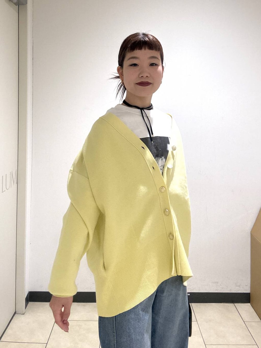 ブルー系のデニムパンツ、ブラック系のブーツ、イエロー系のカーディガン/ボレロを着用したレディースの冬コーディネートの7枚目の写真