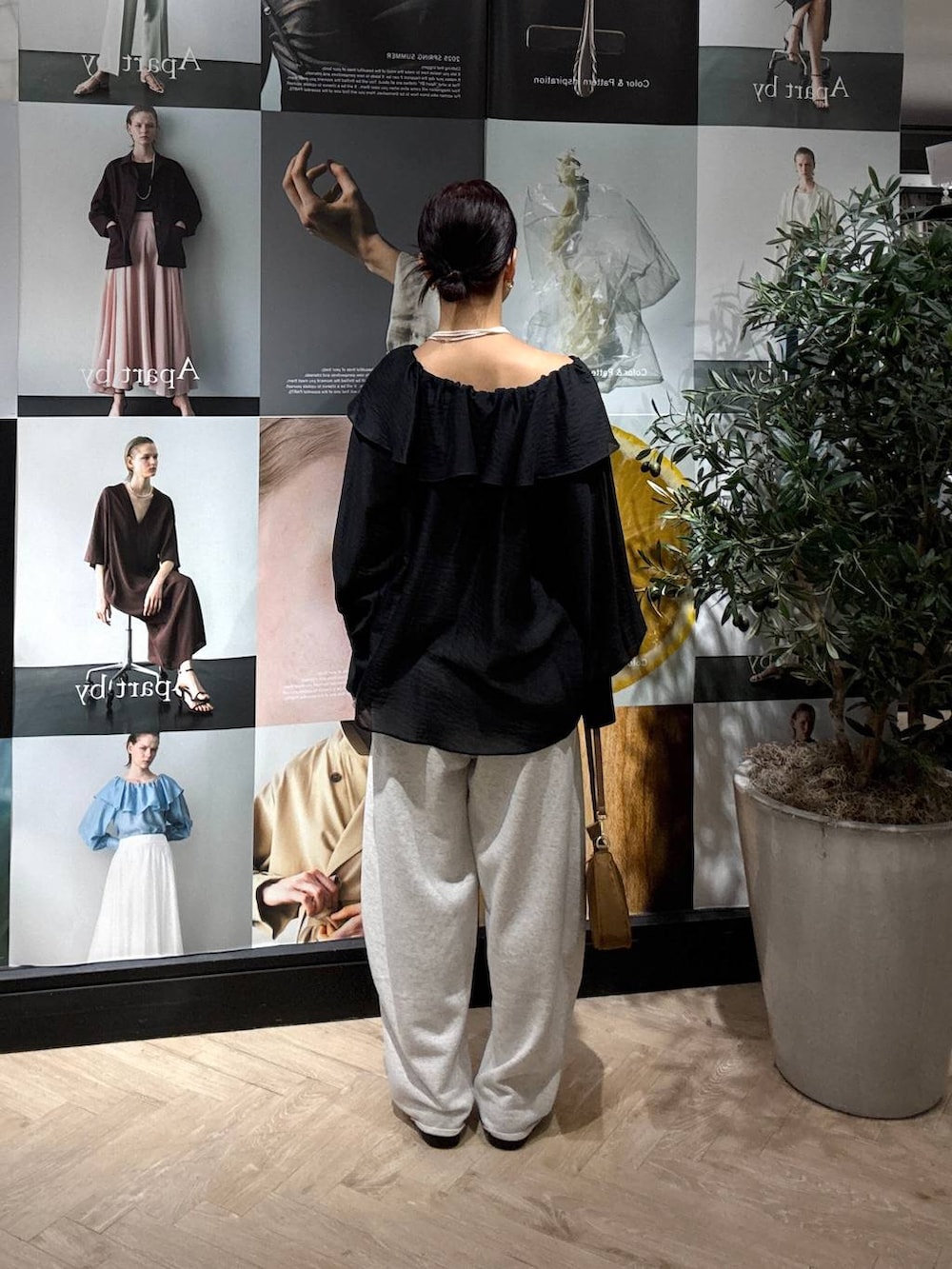 ブラック系のシャツ/ブラウス、グレー系のスウェットパンツ、イエロー系のショルダーバッグを着用したレディースの夏コーディネートの3枚目の写真