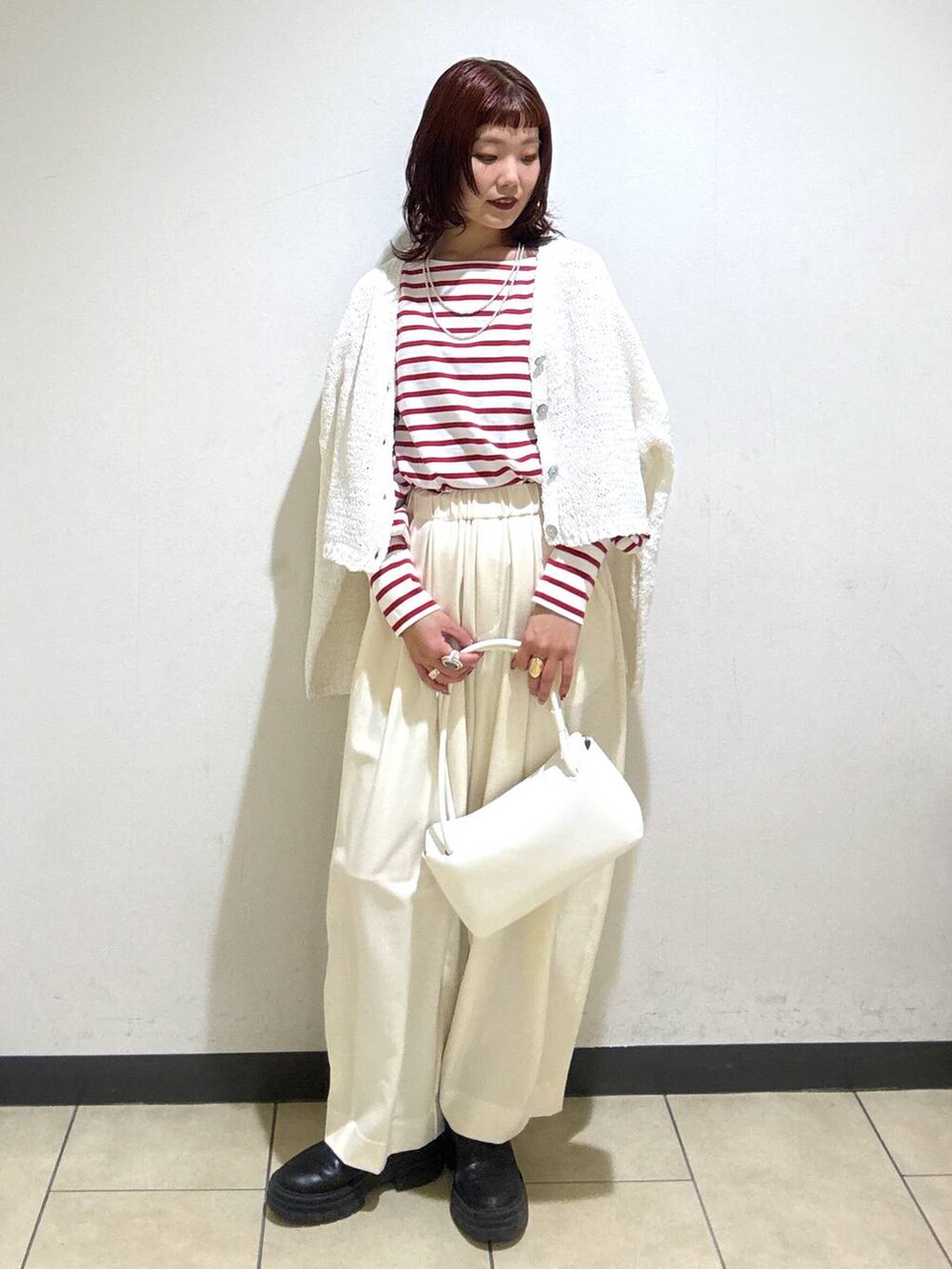 ホワイト系のスラックス、ブラック系のローファー、ホワイト系のショルダーバッグを着用したレディースの冬コーディネートの5枚目の写真