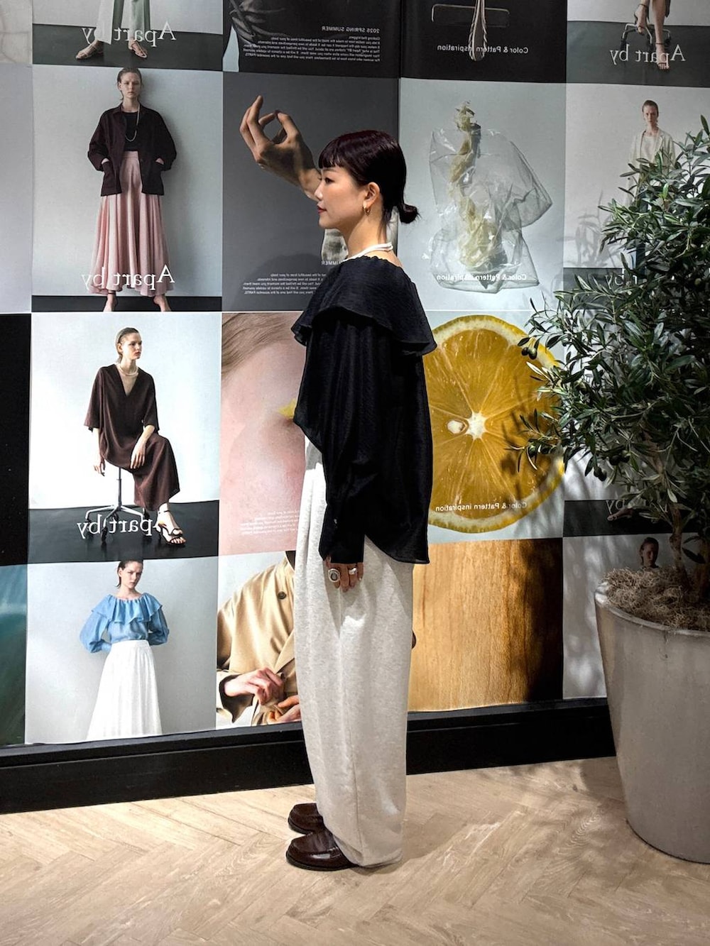 ブラック系のシャツ/ブラウス、グレー系のスウェットパンツ、イエロー系のショルダーバッグを着用したレディースの夏コーディネートの2枚目の写真