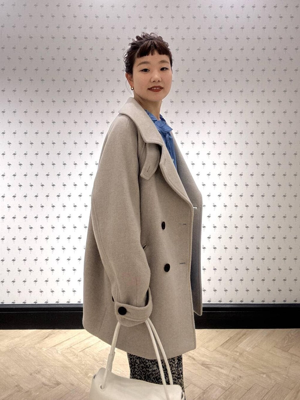 ベージュ系のピーコート、ブラウン系のスカート、ブラック系のローファーを着用したレディースの冬コーディネートの6枚目の写真