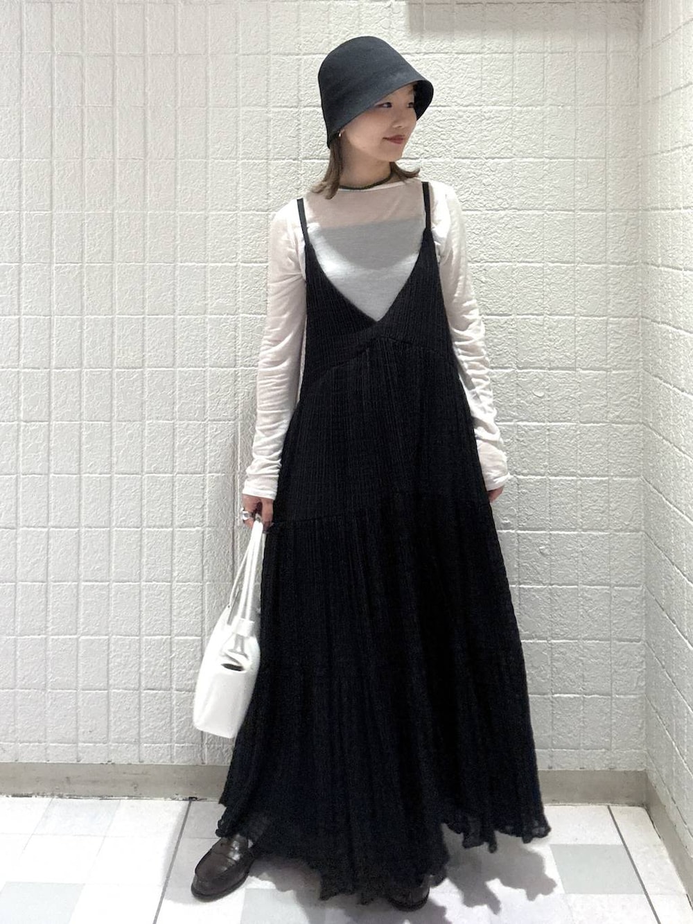 ホワイト系のTシャツ/カットソー、ホワイト系のショルダーバッグ、ブラック系のワンピースを着用したレディースの春コーディネートの5枚目の写真