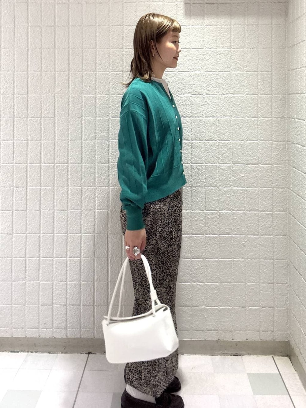 グリーン系のカーディガン/ボレロ、ブラウン系のスカート、ホワイト系のショルダーバッグを着用したレディースの春コーディネートの3枚目の写真