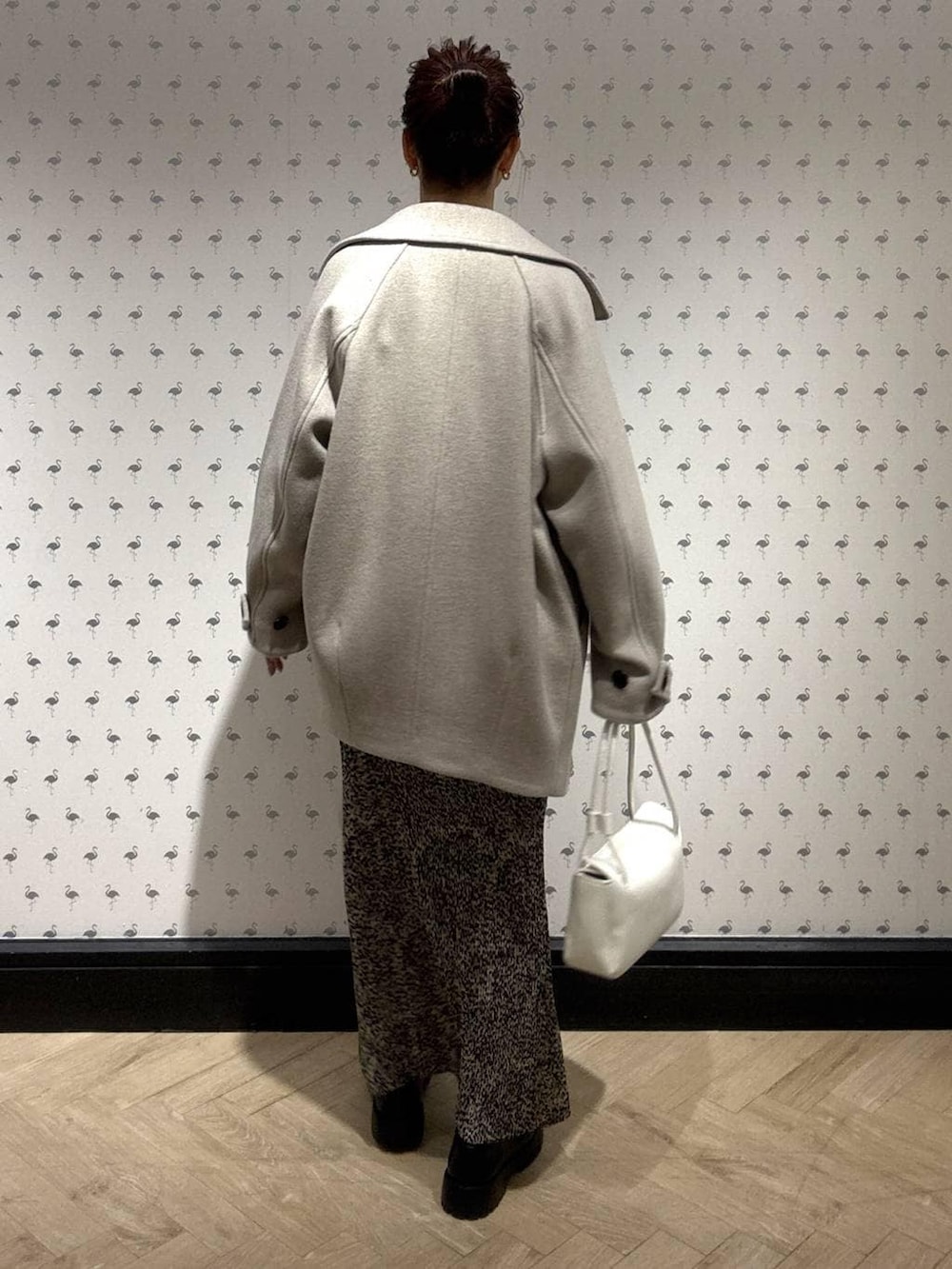 ベージュ系のピーコート、ブラウン系のスカート、ブラック系のローファーを着用したレディースの冬コーディネートの4枚目の写真