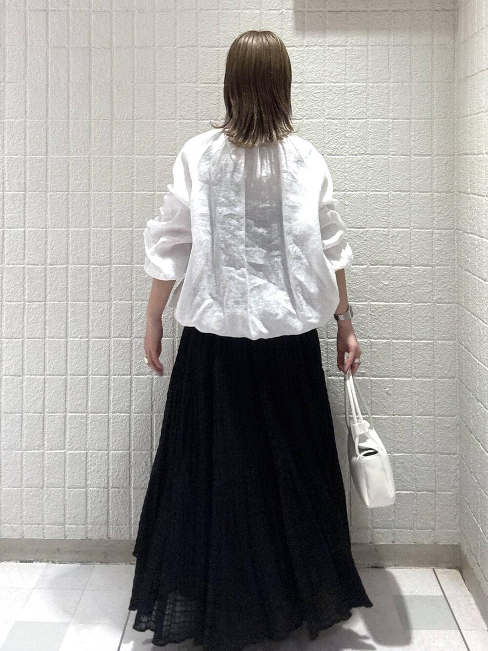 ホワイト系のショルダーバッグ、ホワイト系のブルゾン、ブラック系のワンピースを着用したレディースの春コーディネートの4枚目の写真