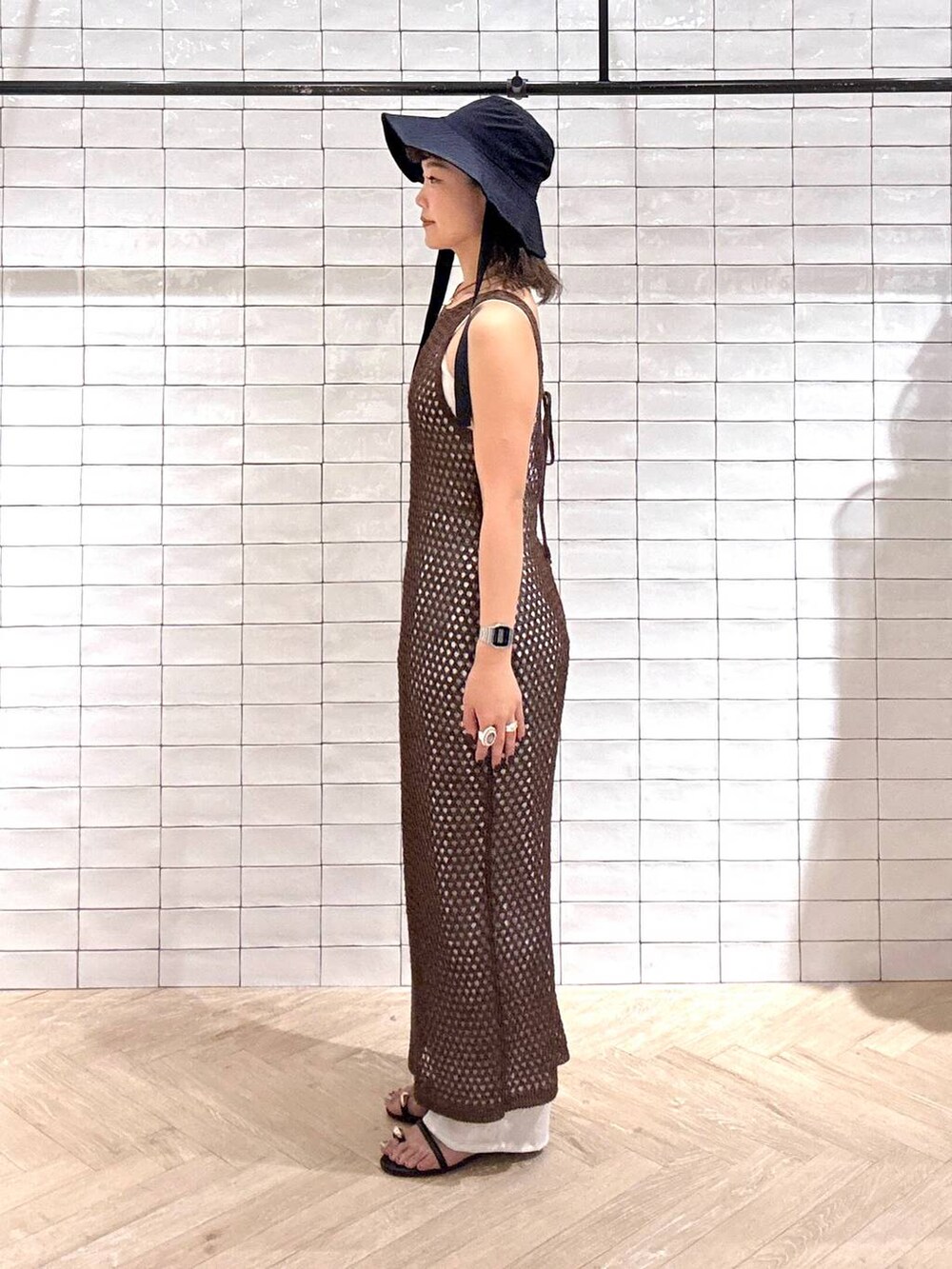 ブラック系のサンダル、ホワイト系のその他パンツ、ブラウン系のワンピースを着用したレディースの春コーディネートの2枚目の写真