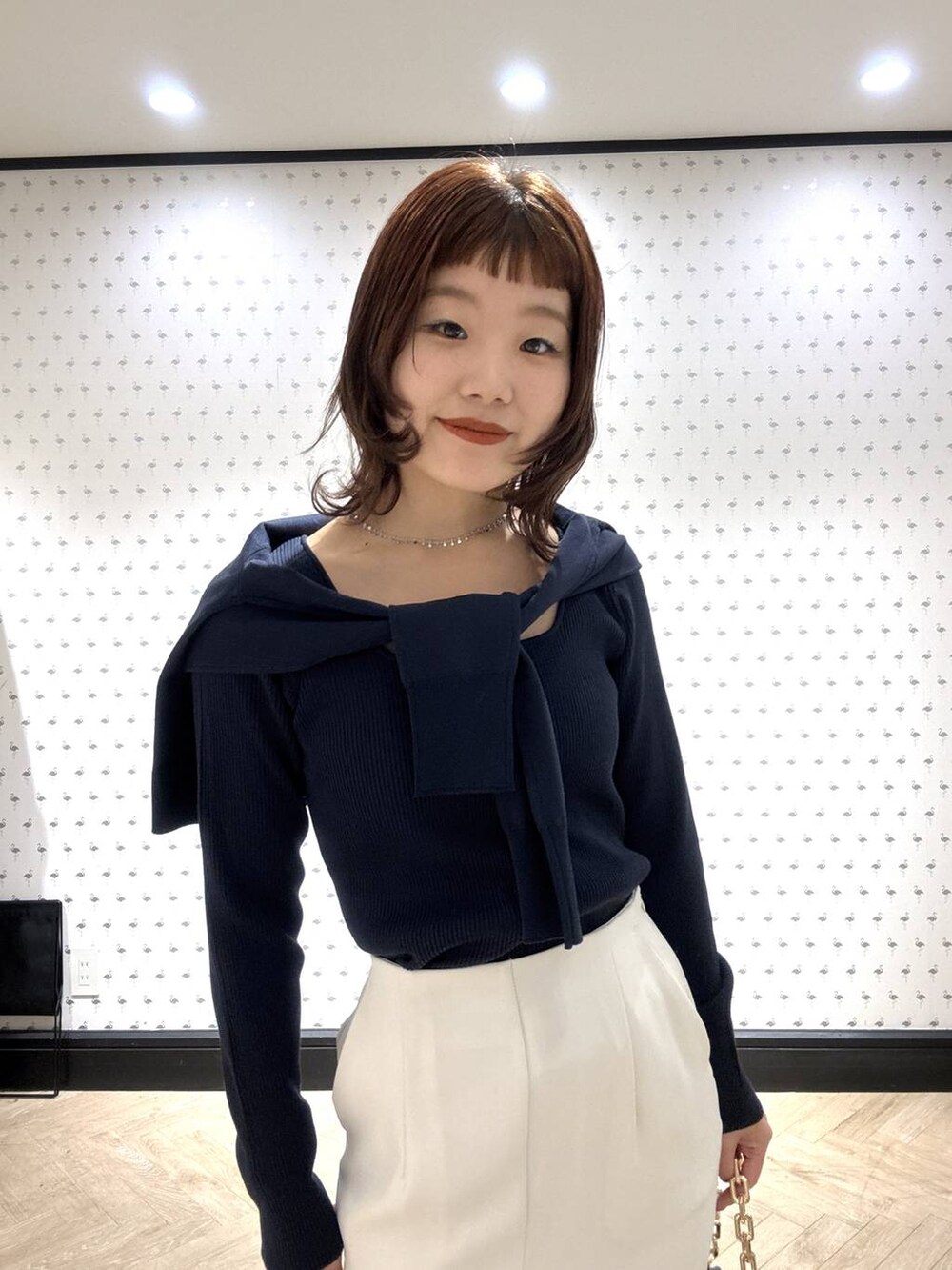 ブラック系のショルダーバッグ、ブルー系のカーディガン/ボレロ、ブルー系のニット/セーターを着用したレディースの冬コーディネートの6枚目の写真