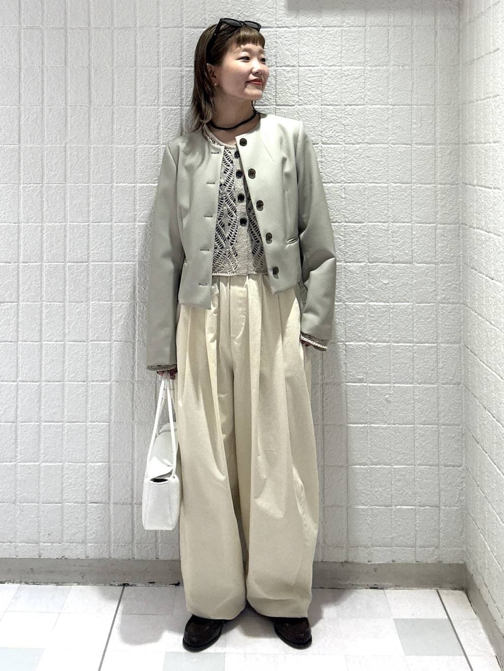ホワイト系のショルダーバッグ、ベージュ系のカーディガン/ボレロ、ベージュ系のノーカラージャケットを着用したレディースの春コーディネートの2枚目の写真