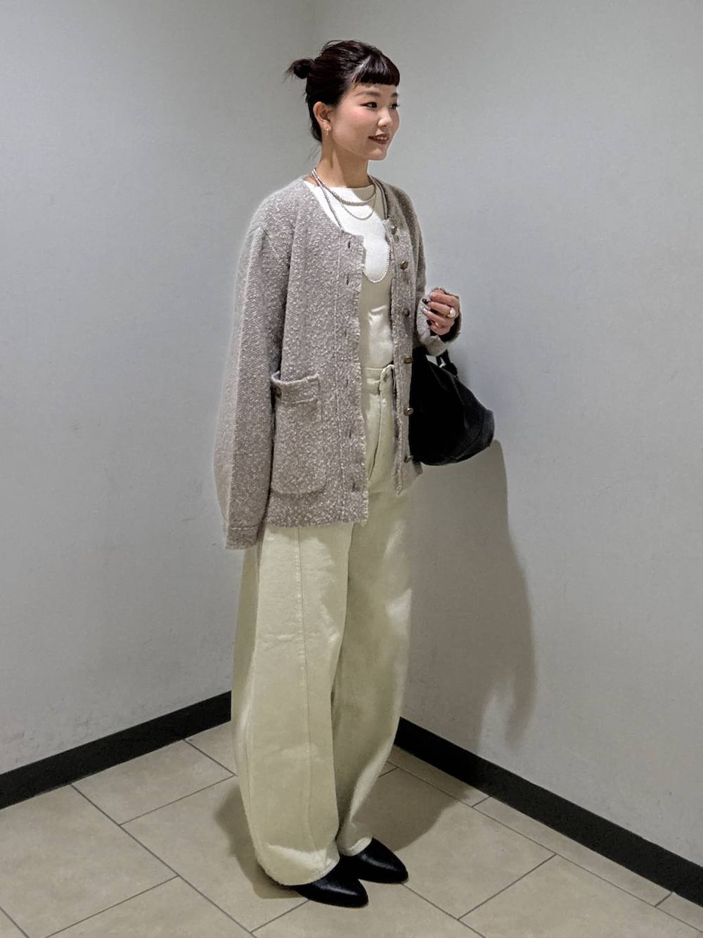 ベージュ系のデニムパンツ、ブラック系のブーツ、ホワイト系のニット/セーターを着用したレディースの秋コーディネートの3枚目の写真