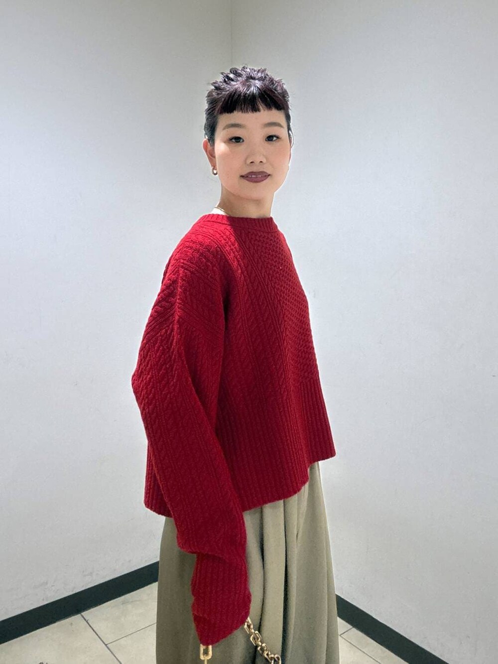 ベージュ系のスラックス、ブラック系のブーツ、ベージュ系のショルダーバッグを着用したレディースの冬コーディネートの7枚目の写真