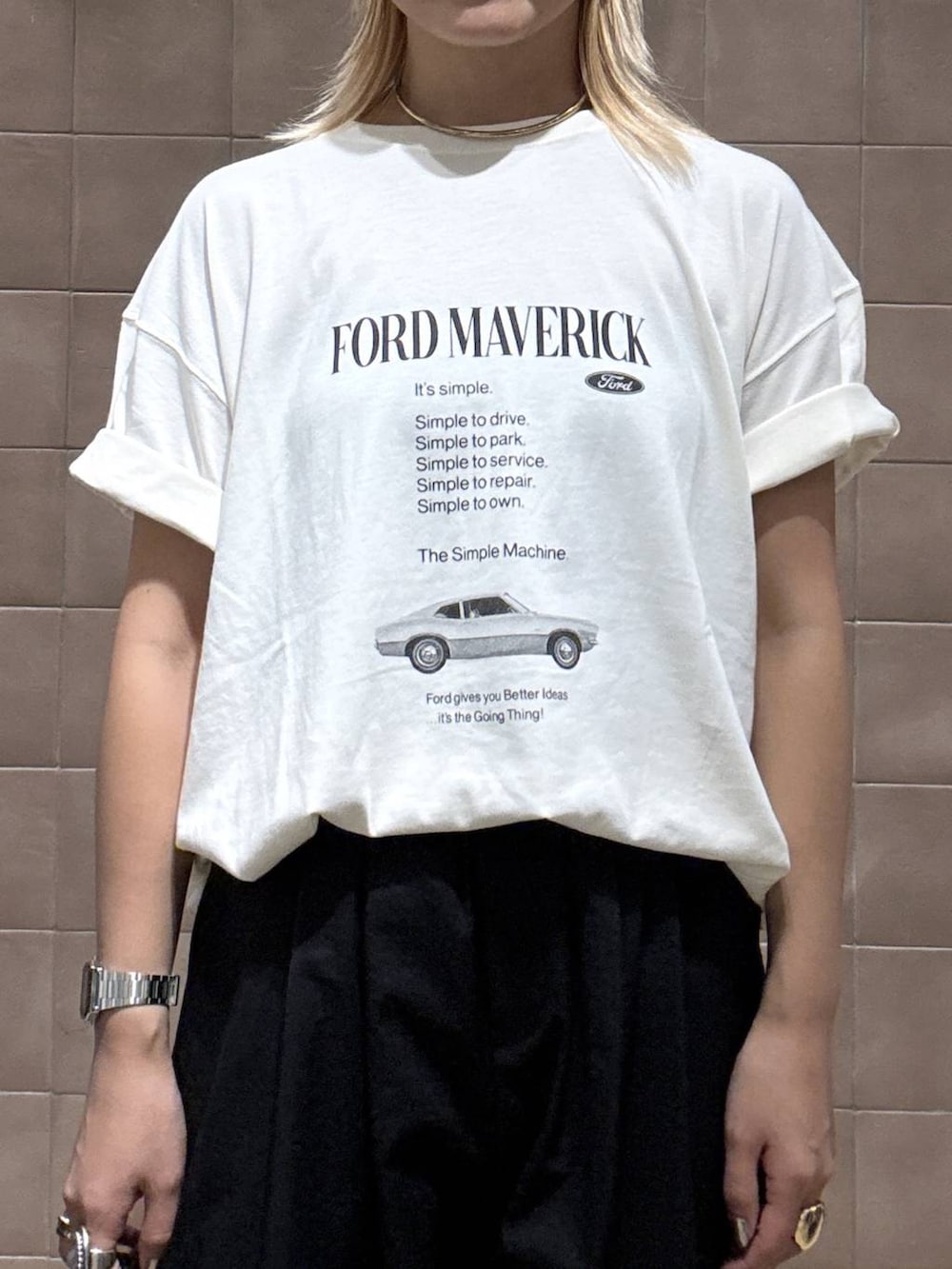 ブラック系のショルダーバッグ、ホワイト系のTシャツ/カットソー、ブラック系のサンダルを着用したレディースの夏コーディネートの2枚目の写真