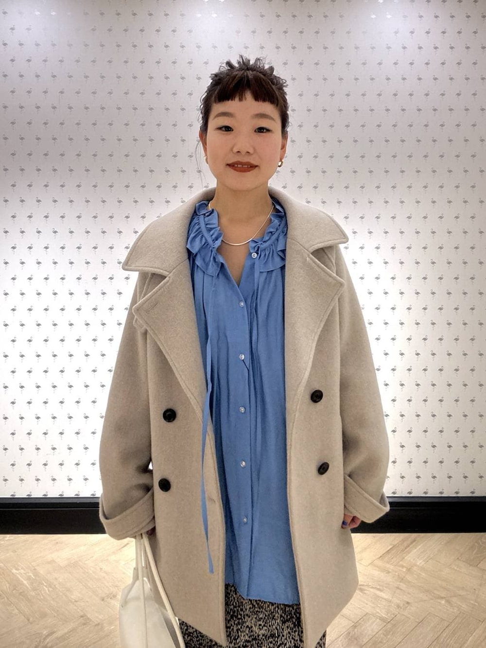 ベージュ系のピーコート、ブラウン系のスカート、ブラック系のローファーを着用したレディースの冬コーディネートの5枚目の写真