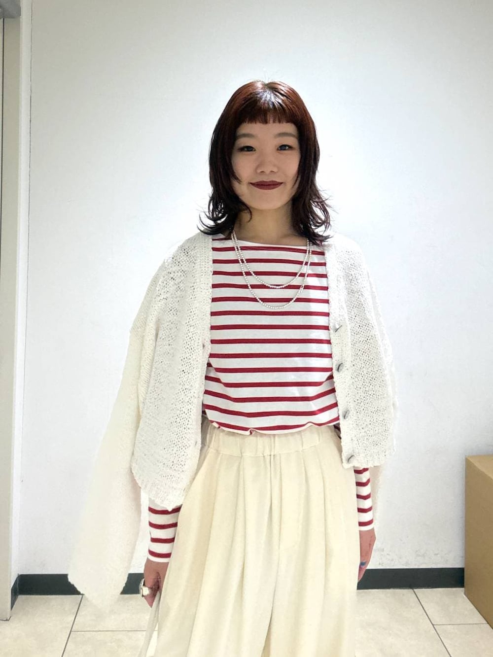 ホワイト系のスラックス、ブラック系のローファー、ホワイト系のショルダーバッグを着用したレディースの冬コーディネートの6枚目の写真