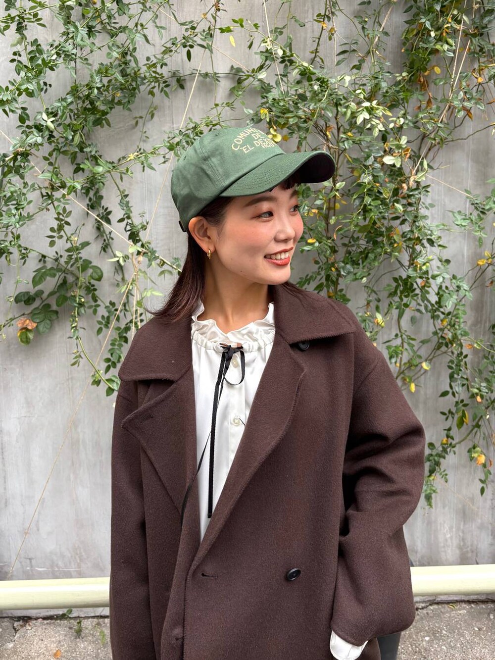 ブラウン系のステンカラーコート、ブルー系のデニムパンツ、ホワイト系のシャツ/ブラウスを着用したレディースの秋コーディネートの5枚目の写真