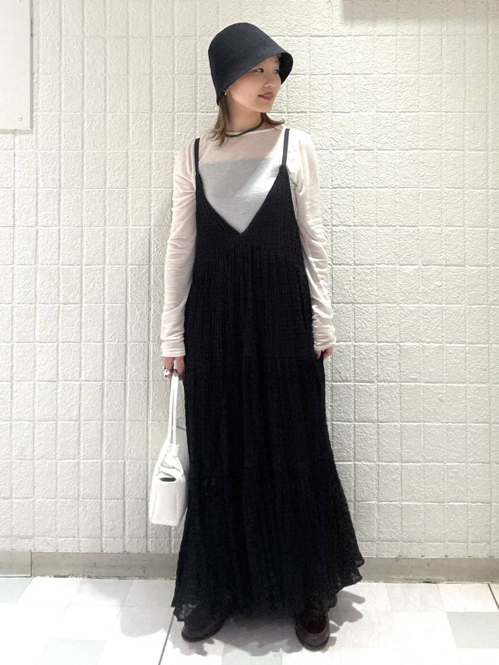 ホワイト系のTシャツ/カットソー、ホワイト系のショルダーバッグ、ブラック系のワンピースを着用したレディースの春コーディネートの6枚目の写真