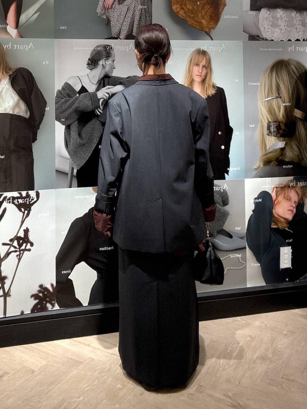 ブラック系のショルダーバッグ、グレー系のスカート、グレー系のテーラードジャケットを着用したレディースの秋コーディネートの4枚目の写真