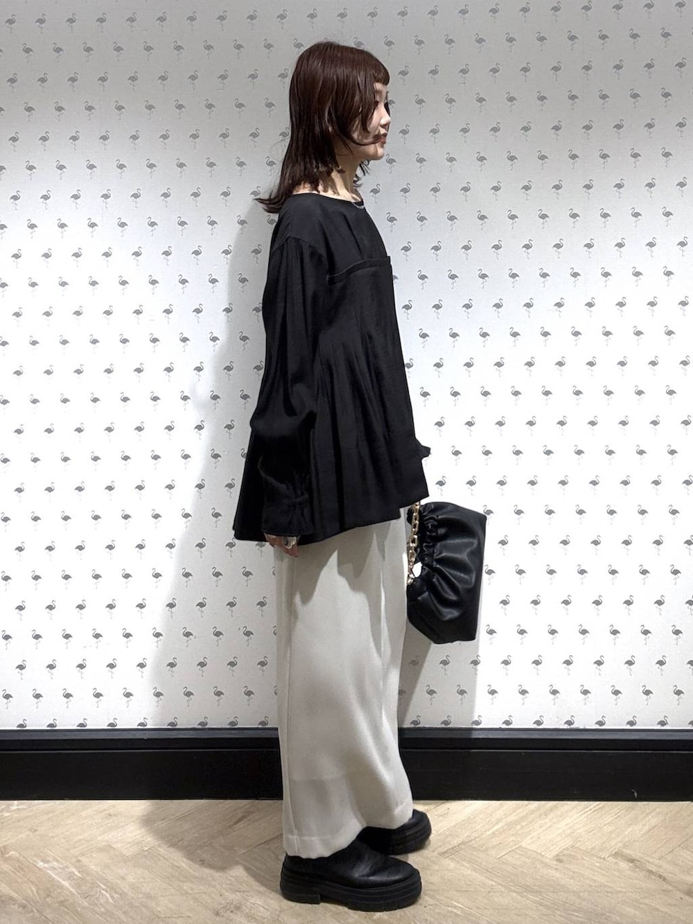 ブラック系のショルダーバッグ、ブラック系のシャツ/ブラウス、ホワイト系のスカートを着用したレディースの冬コーディネートの3枚目の写真