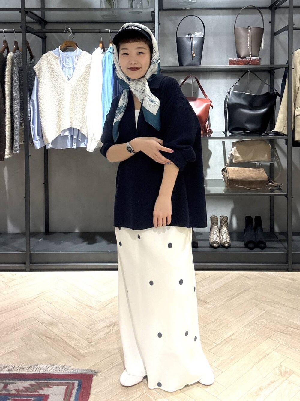 ホワイト系のスニーカー、ブルー系のニット/セーター、ホワイト系のスカートを着用したレディースの冬コーディネートの2枚目の写真