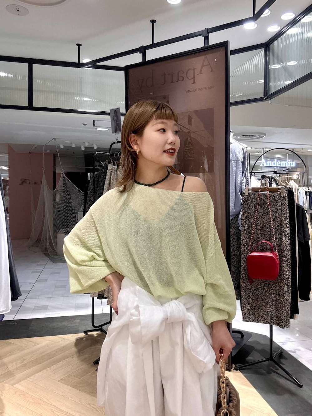 ホワイト系のシャツ/ブラウス、ベージュ系のショルダーバッグ、グリーン系のニット/セーターを着用したレディースの春コーディネートの3枚目の写真