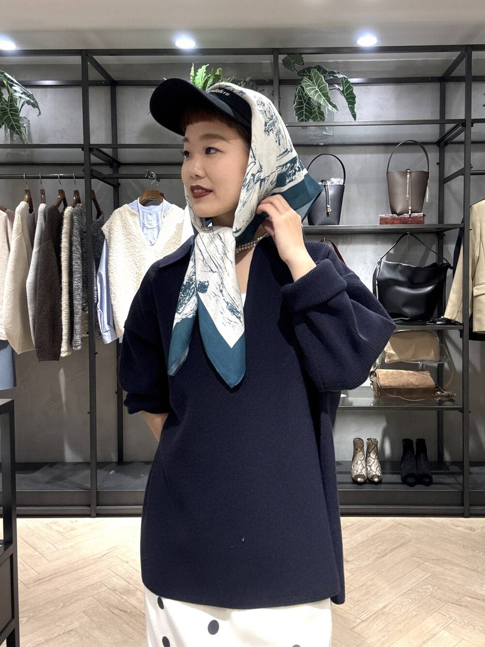 ホワイト系のスニーカー、ブルー系のニット/セーター、ホワイト系のスカートを着用したレディースの冬コーディネートの7枚目の写真