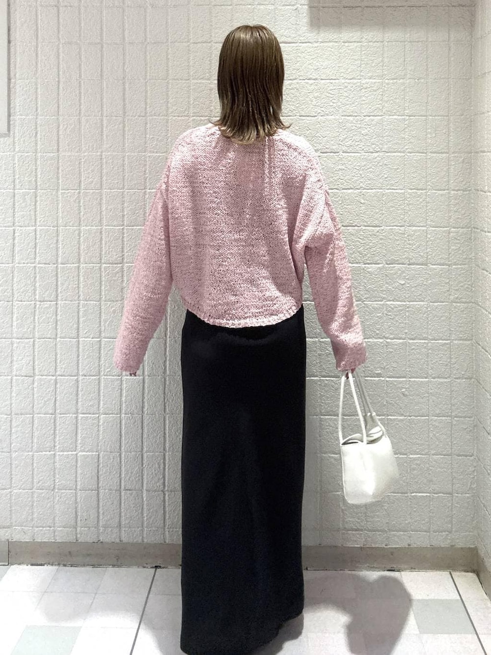 ホワイト系のショルダーバッグ、ピンク系のカーディガン/ボレロ、ブラック系のスカートを着用したレディースの春コーディネートの4枚目の写真