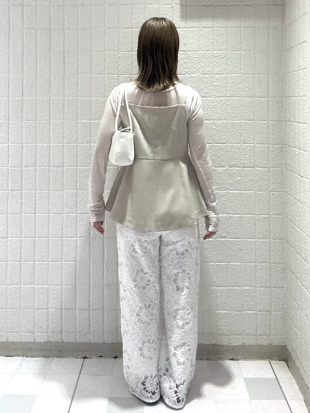 ベージュ系のベスト、ホワイト系のTシャツ/カットソー、ホワイト系のショルダーバッグを着用したレディースの春コーディネートの4枚目の写真