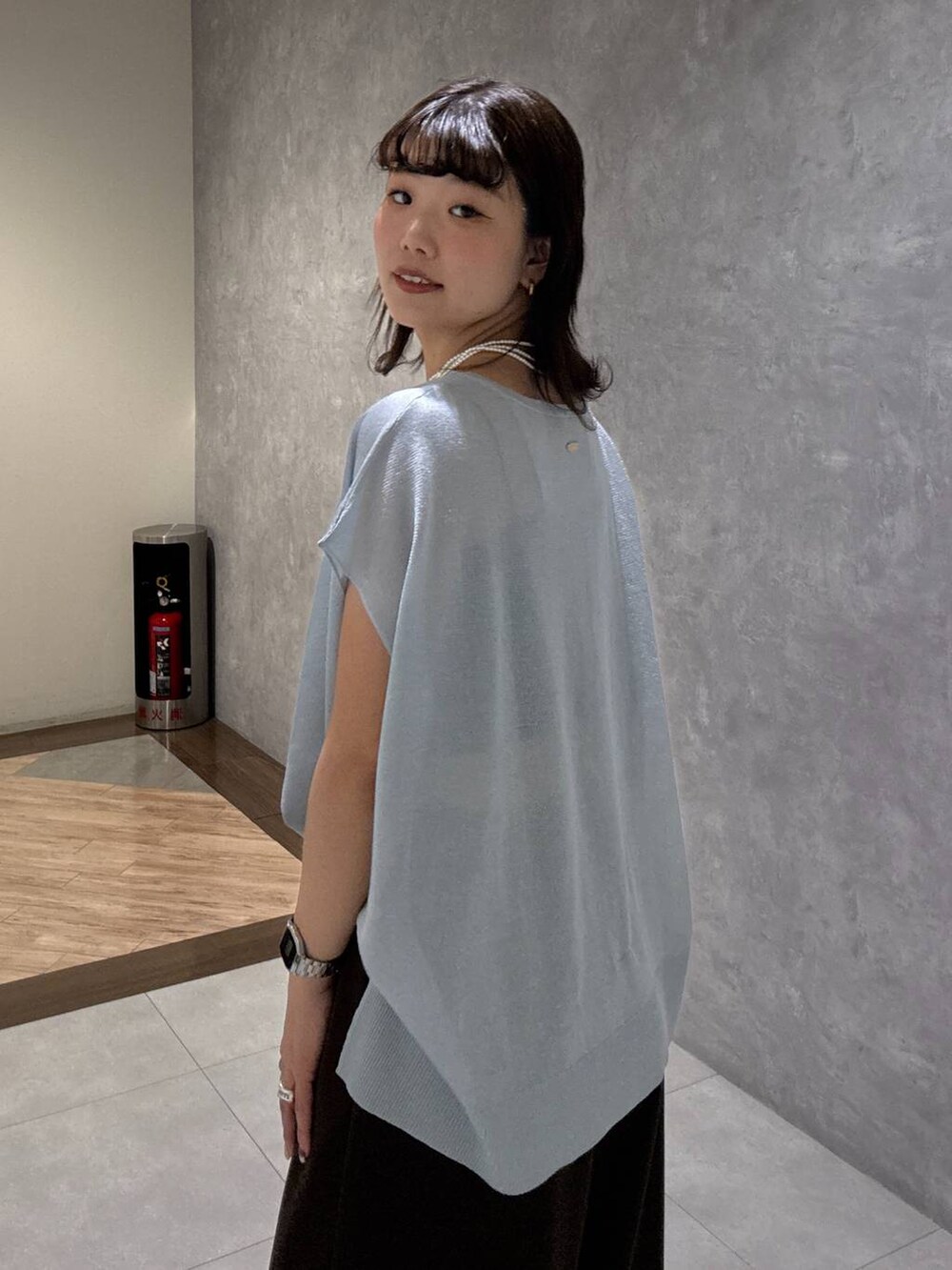 ブラック系のサンダル、ブラウン系のスラックス、ブルー系のニット/セーターを着用したレディースの夏コーディネートの6枚目の写真