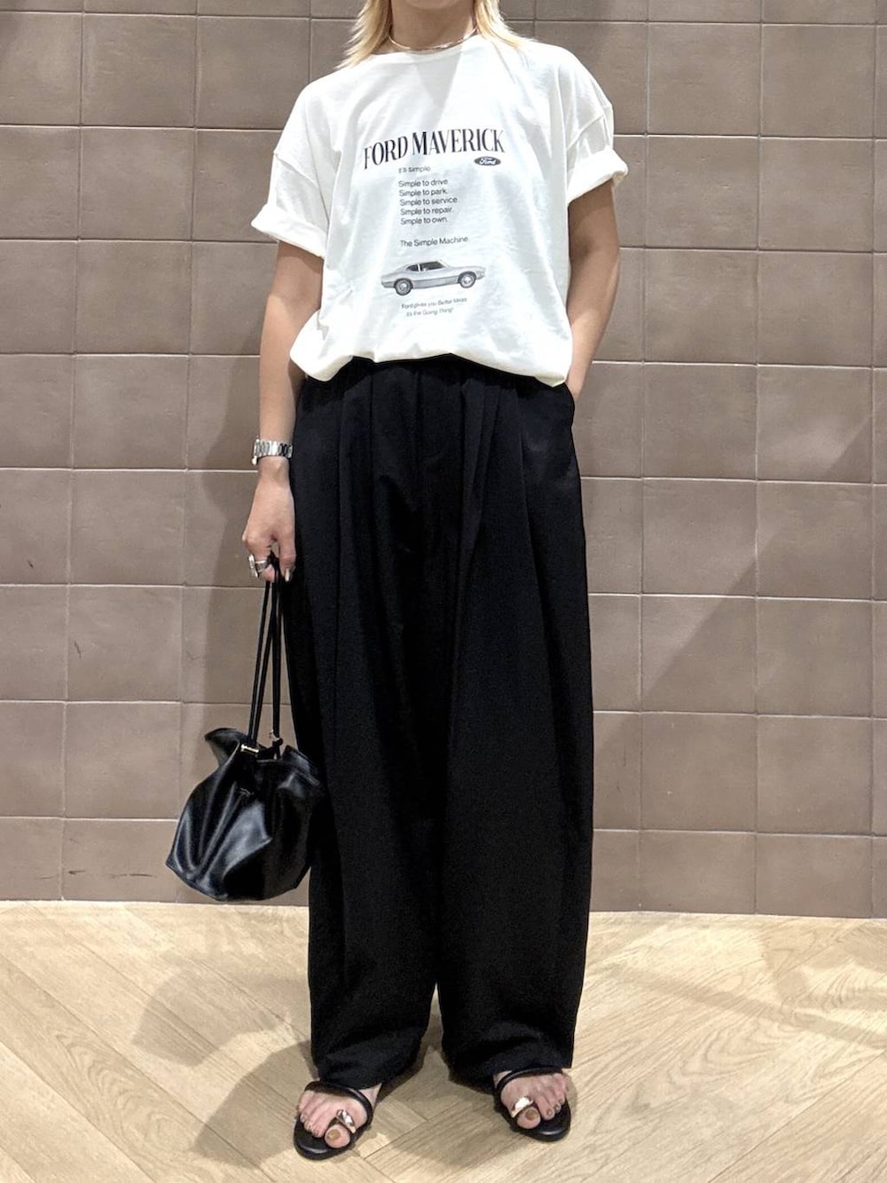 ブラック系のショルダーバッグ、ホワイト系のTシャツ/カットソー、ブラック系のサンダルを着用したレディースの夏コーディネートの3枚目の写真