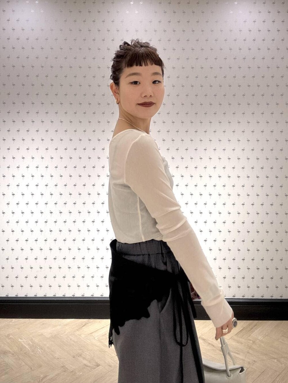 グレー系のスラックス、ホワイト系のTシャツ/カットソー、ブラック系のブーツを着用したレディースの冬コーディネートの7枚目の写真