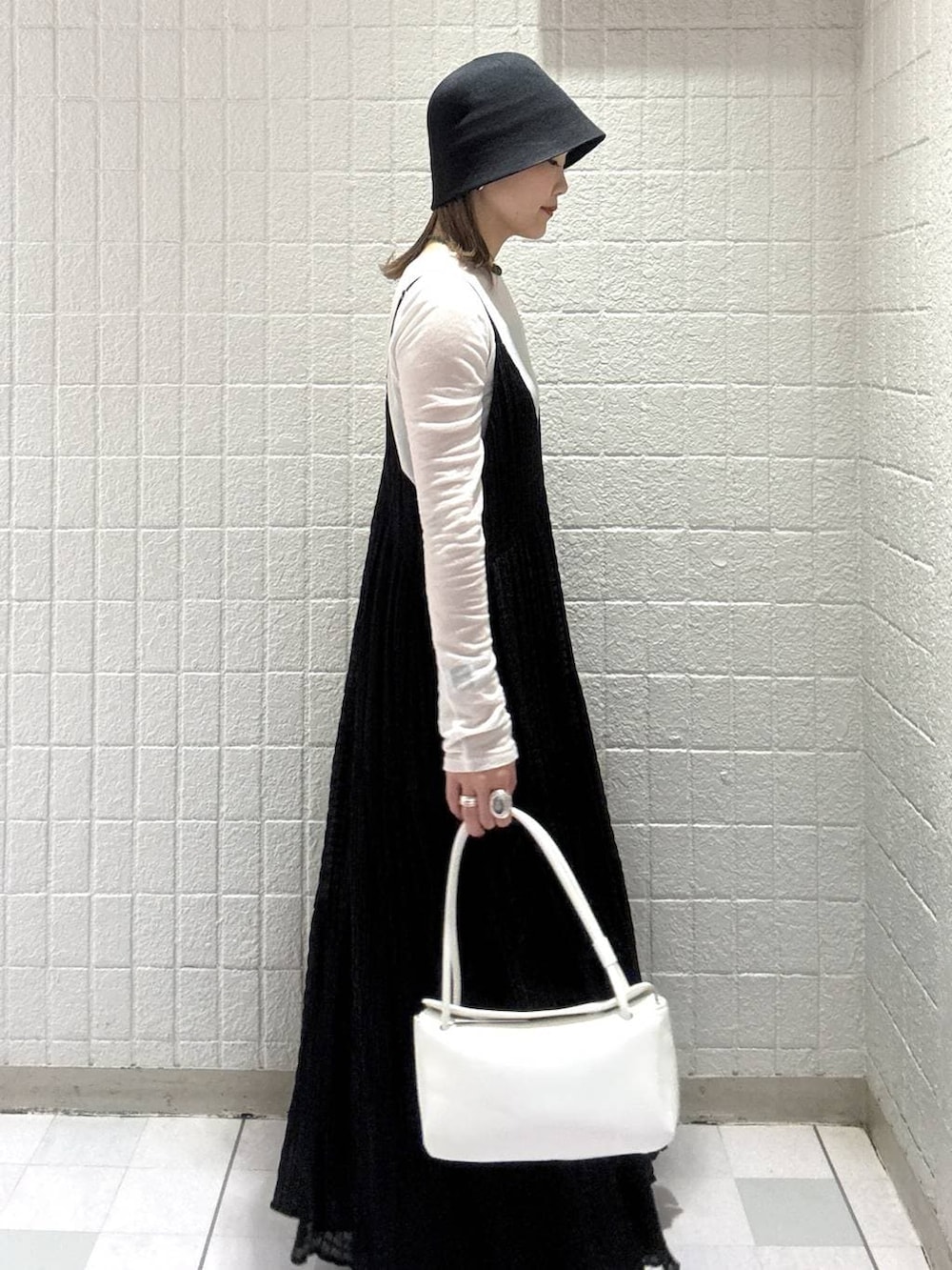 ホワイト系のTシャツ/カットソー、ホワイト系のショルダーバッグ、ブラック系のワンピースを着用したレディースの春コーディネートの3枚目の写真