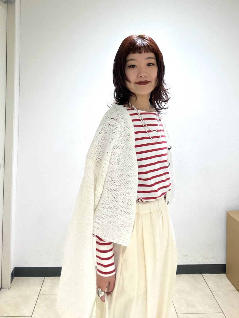 ホワイト系のスラックス、ブラック系のローファー、ホワイト系のショルダーバッグを着用したレディースの冬コーディネートの7枚目の写真