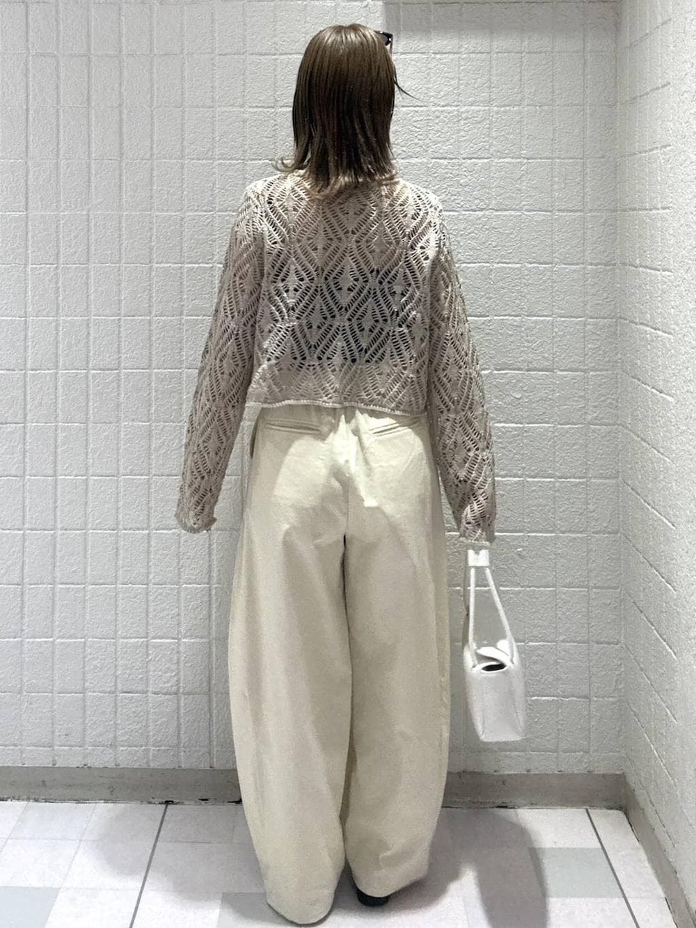 ホワイト系のショルダーバッグ、ベージュ系のカーディガン/ボレロ、ブラウン系のサングラスを着用したレディースの春コーディネートの4枚目の写真