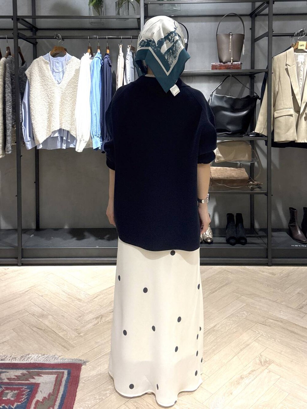 ホワイト系のスニーカー、ブルー系のニット/セーター、ホワイト系のスカートを着用したレディースの冬コーディネートの5枚目の写真